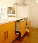 AFTER：家族が協力しやすいように、リビング側にレンジ、炊飯器などを置く収納棚を配置。 キッチン、カップボードも収納力たっぷり。